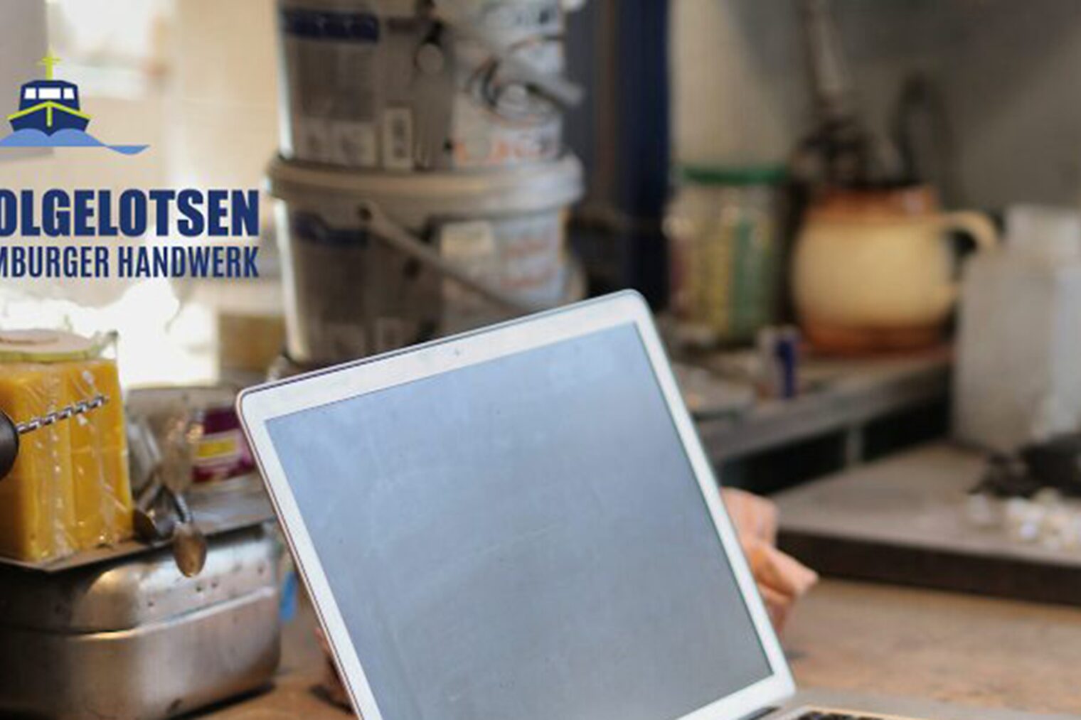 Nachfolgelotsen für das Hamburger Handwerk: Veranstaltungen der Übernehmer*innenschmiede Laptop in Werkstatt mit dem Logo der Hamburger Nachfolgelotsen