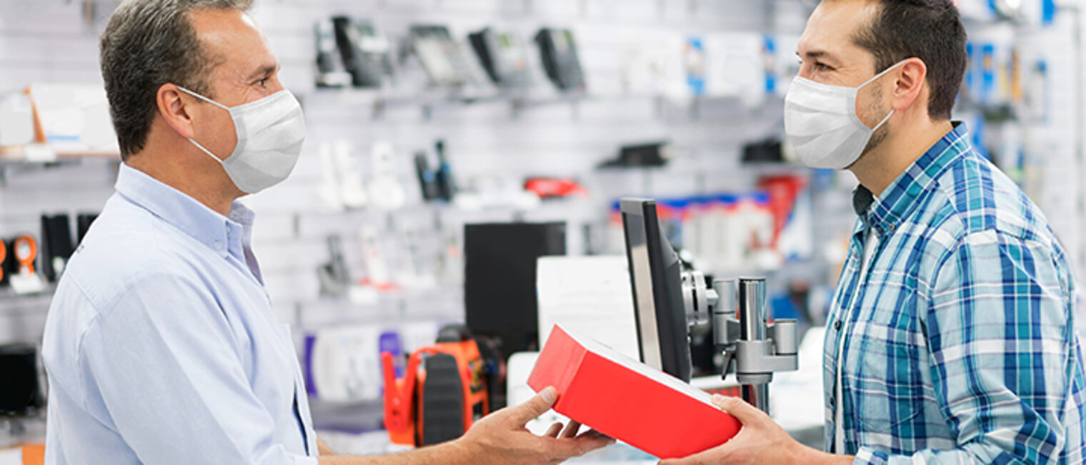 Latin American man wearing a facemask while shopping at a tech store during the COVID-19 pandemic