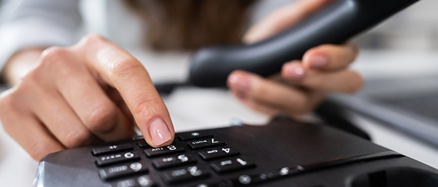 Close-up Of A Businesswoman's Hand Calling On Landline