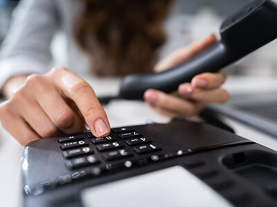 Close-up Of A Businesswoman's Hand Calling On Landline