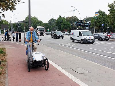 Glasermeister Jörg Hauschildt fährt mit seinem Lastenrad auf dem Radweg.