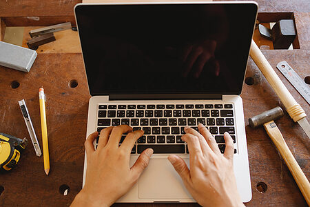 aufgeklappter Laptop, zehn Finger tippen