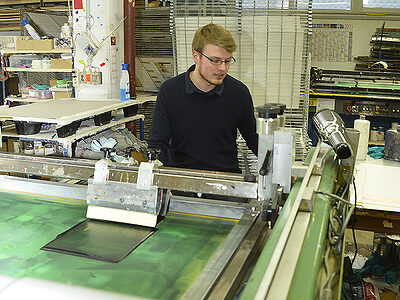 junger Mann arbeitet in der Siebdruckerei