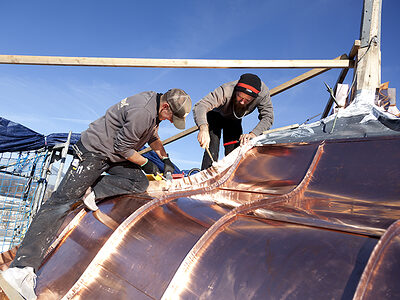 Zwei Klempner restaurieren ein Kupferdach