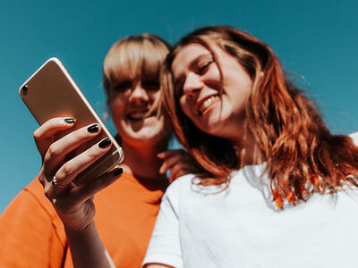 zwei junge Frauen schauen auf ein Smartphone