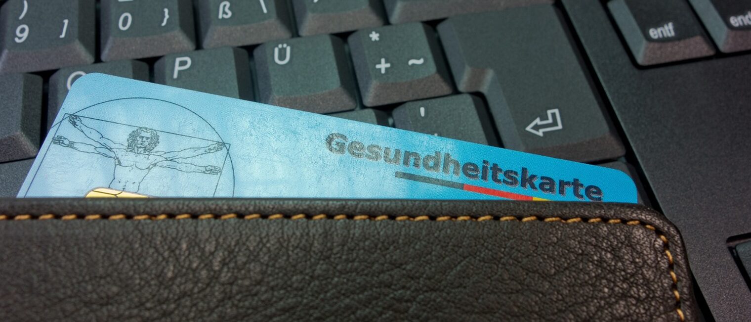 eine Krankenkassenkarte auf der Tastatur eines PC eine Krankenkassenkarte auf der Tastatur eines PC