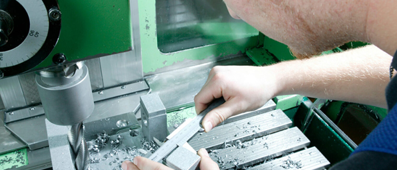 Ein Feinwerkmechaniker nimmt an einem Werkstück Maß.
