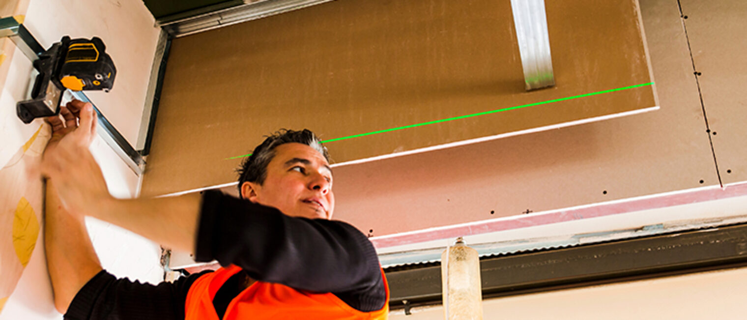 Bauhandwerker vermisst einen Raum mittels Laserscanning. Bauhandwerker vermisst einen Raum mittels Laserscanning.