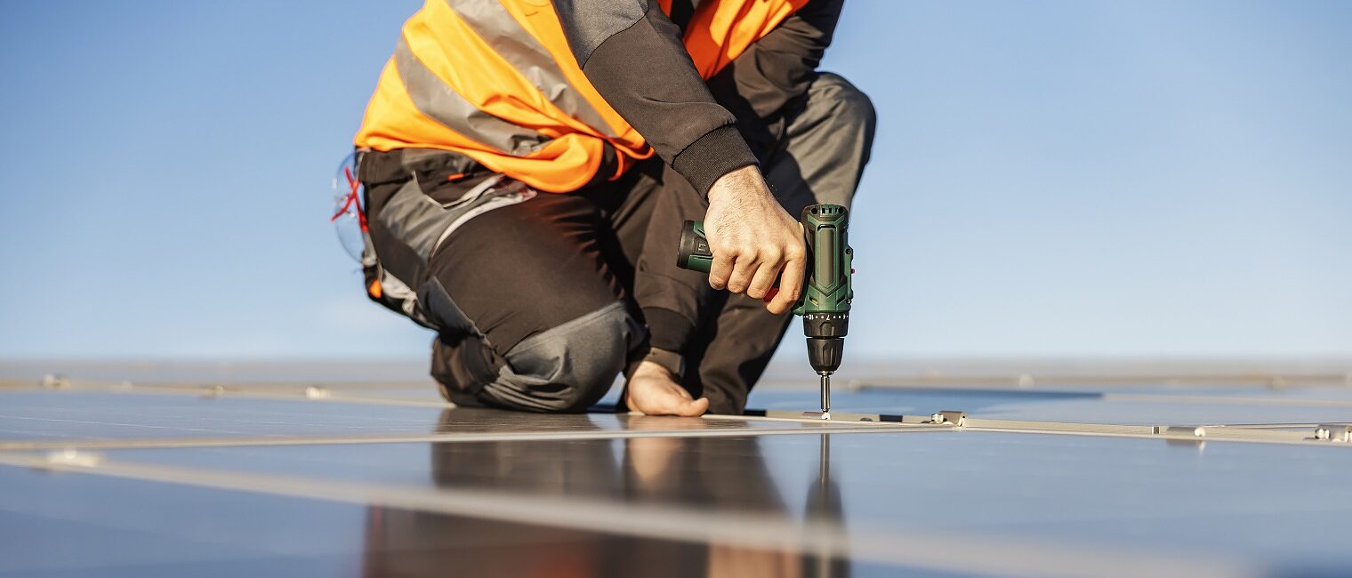 Unrecognizable handyman installing solar panels.