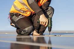 Unrecognizable handyman installing solar panels.
