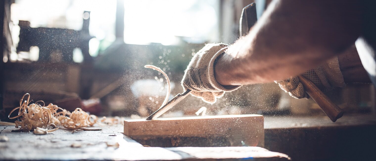 Manual worker working with wood in carpentry. Close-up shot.