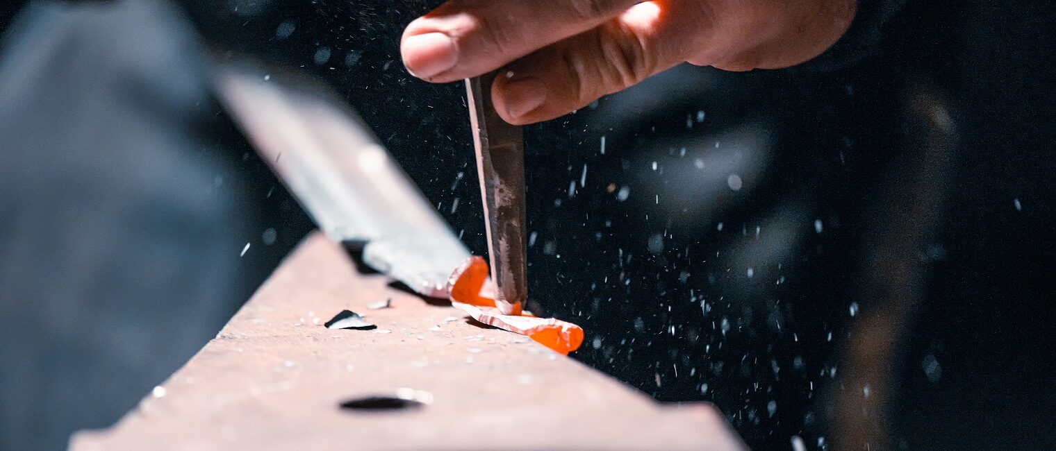 Close-up of the hands of a blacksmith during artistic forging.