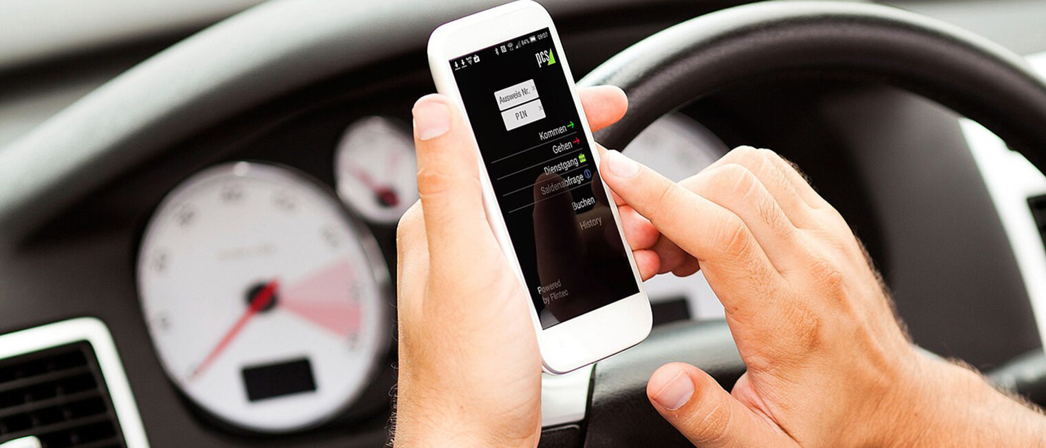 Im Auto: Person, die am Smartphone eine Zeit eingibt.