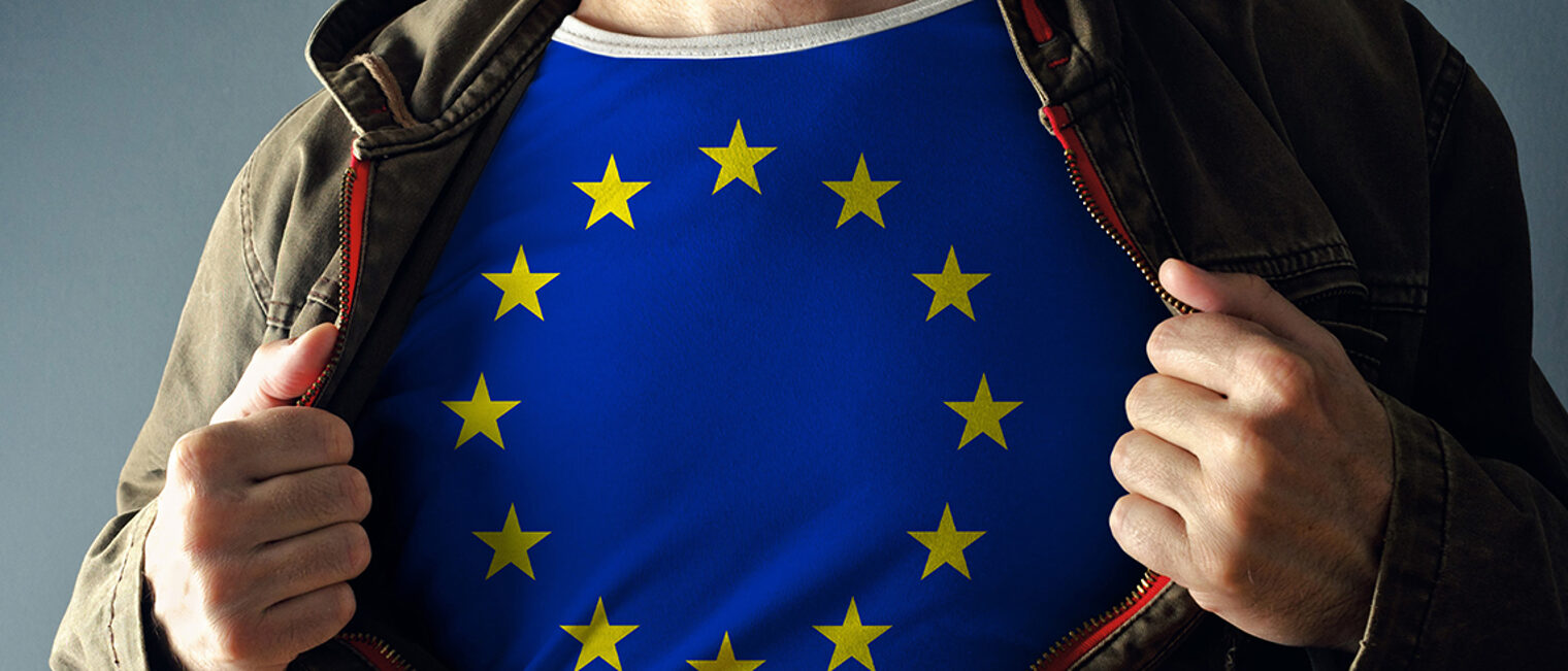 Man stretching jacket to reveal shirt with European Union flag printed. Concept of patriotism and national team supporting. Schlagwort(e): Casual, Caucasian, Chest, Concepts, Country - Geographic Area, Europe, European Community, European Culture, European Union Flag, Fan, Flag, Heroes, Ideas, Jacket, Male, Men, National Flag, National Landmark, Opening, Patriotism, Pride, Shirt, Showing, Spectator, Spreading, Stretching, Success, Support, T-Shirt, Undressing, Urban Scene, nation