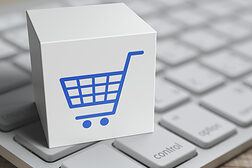 Würfel mit Einkaufswagen-Icon auf einer Laptop-Tastatur