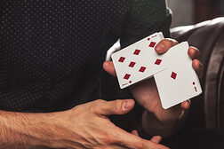Mann hält Spielkarten zwischen den Fingern.