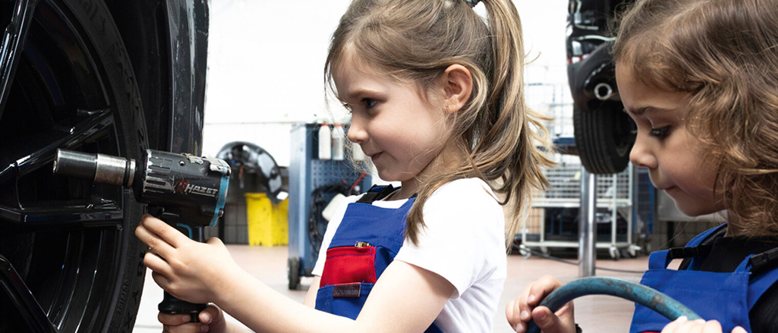 Kinder prüfen Reifendruck in der Kfz-Werkstatt. Kinder prüfen Reifendruck in der Kfz-Werkstatt.