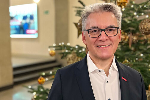 Präsident Hjalmar Stemmann vor dem Weihnachtsbaum im Foyer der Handwerkskammer.