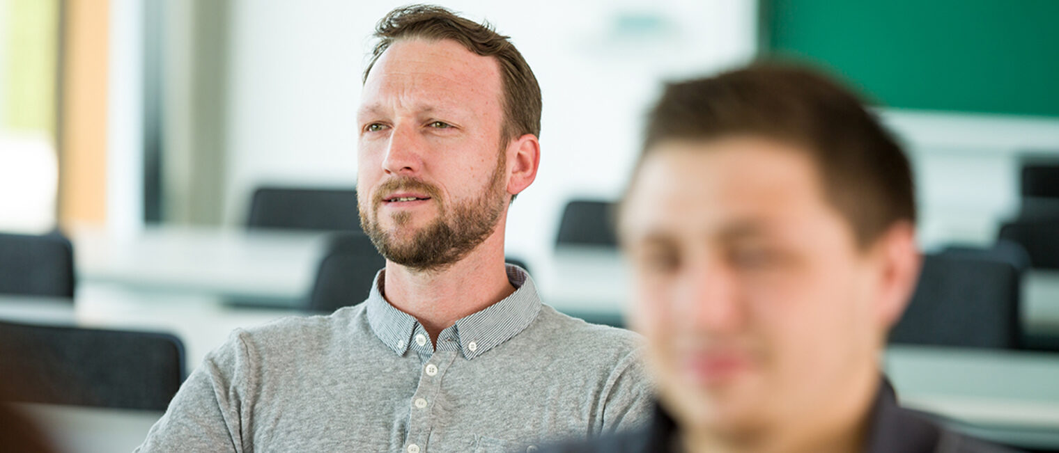 zwei junge Männer in einem Seminarraum