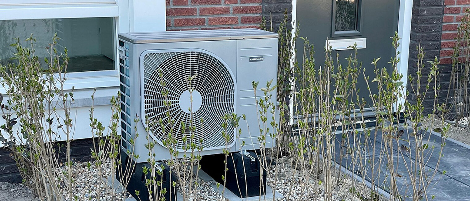 Wärmepumpe neben einer Haustür.