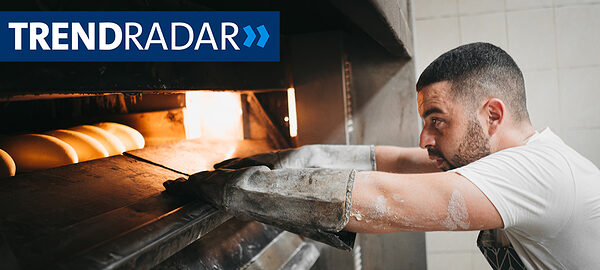 Bäcker schiebt Brot in den Backofen