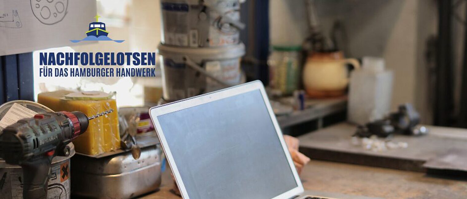 Laptop in Werkstatt mit dem Logo der Hamburger Nachfolgelotsen