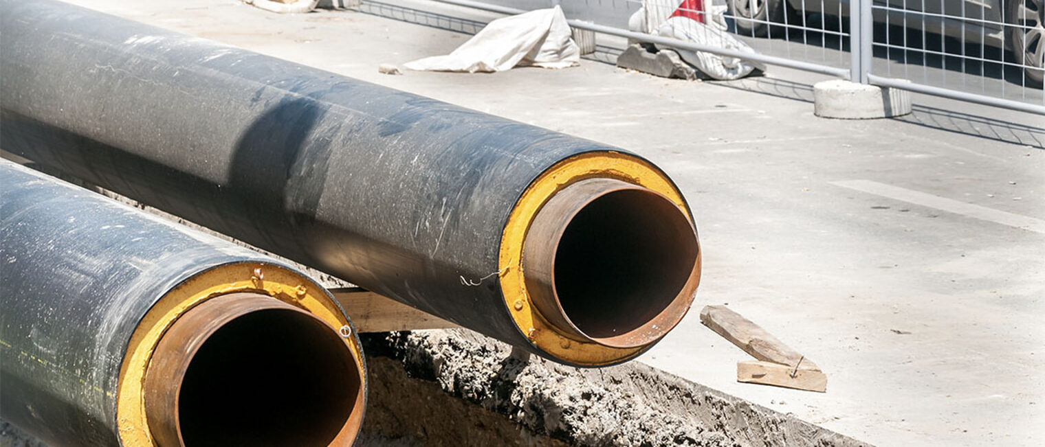 zwei schwarze Rohre auf einer Straßenbaustelle