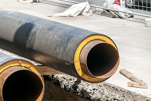 zwei schwarze Rohre auf einer Straßenbaustelle