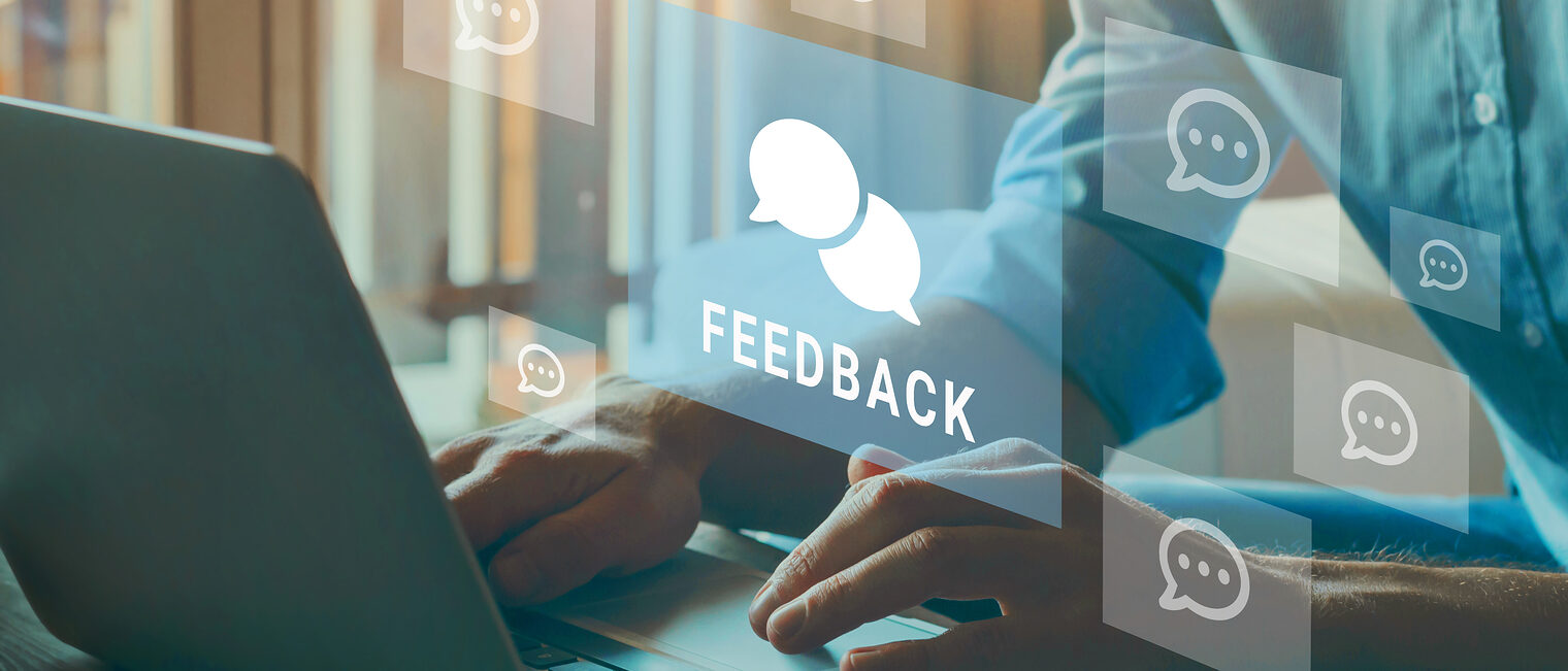 Feedback-Sprechblasen schweben über einem Laptop.