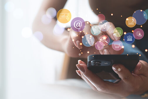 Frau benutzt ein Smartphone, Icons für Online-Einkauf etc. schweben darüber