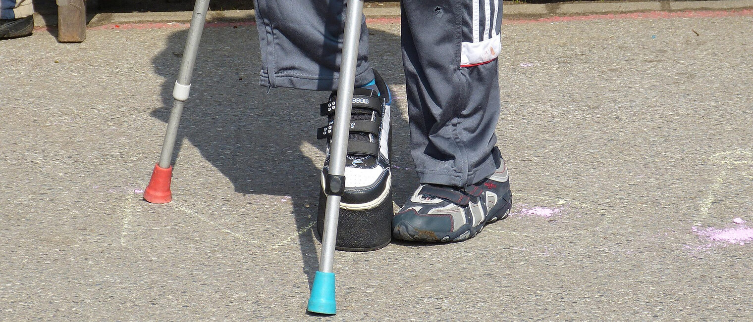 Mensch, gestützt auf Krücken.