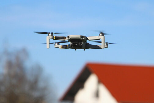 Drohne schwebt neben einem Gebäude.