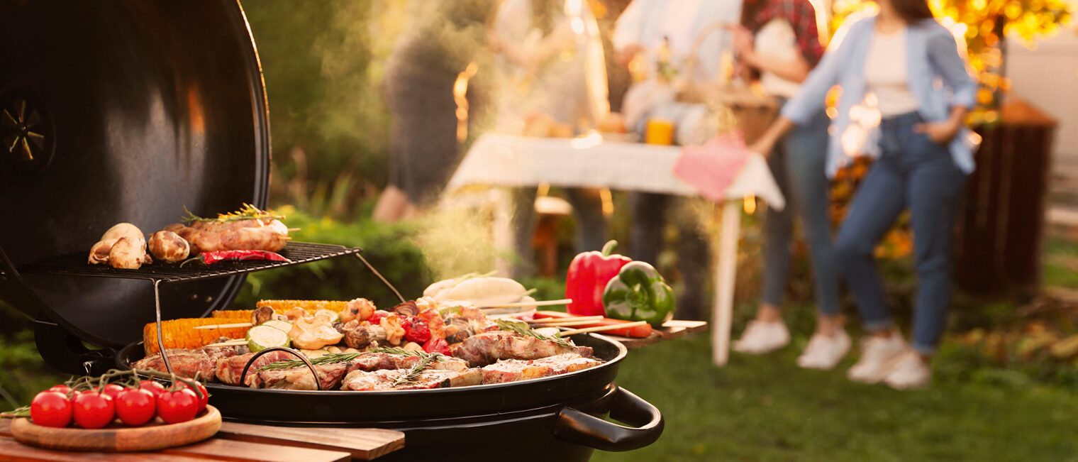 Gruppe von Menschen in einem Garten beim grillen