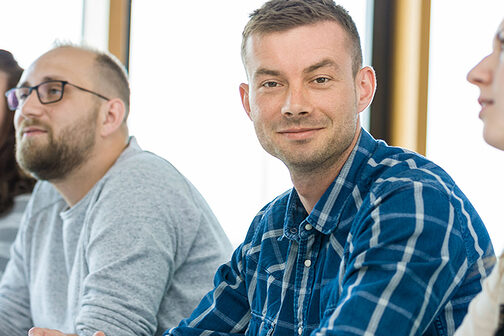 vier junge Menschen in einem Seminarraum