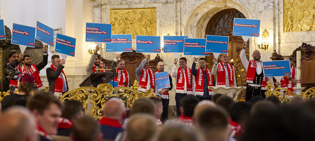Menschen halten Schilder im Altarraum des Michel in die Höhe