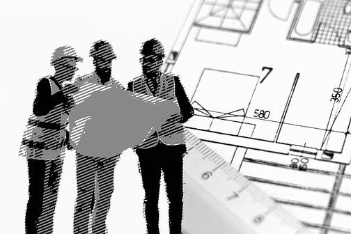 Drei Baubeschäftigte sehen sich Bauzeichnungen an